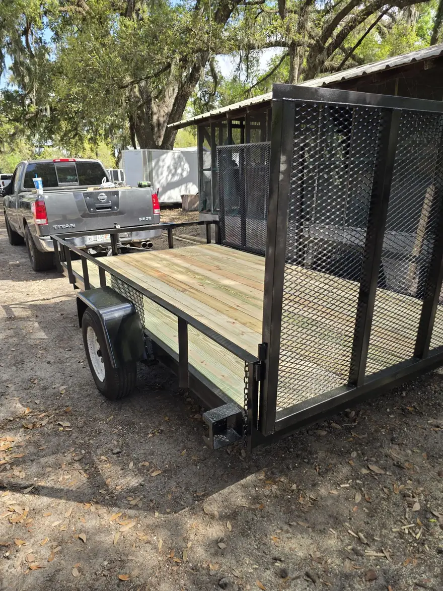 Utility trailer restored to a clean, painted frame with a new deck after blasting