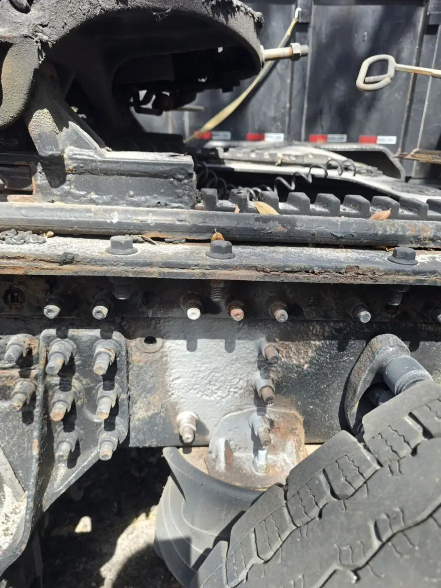 Rusted truck frame rail with corroded bolts before blasting